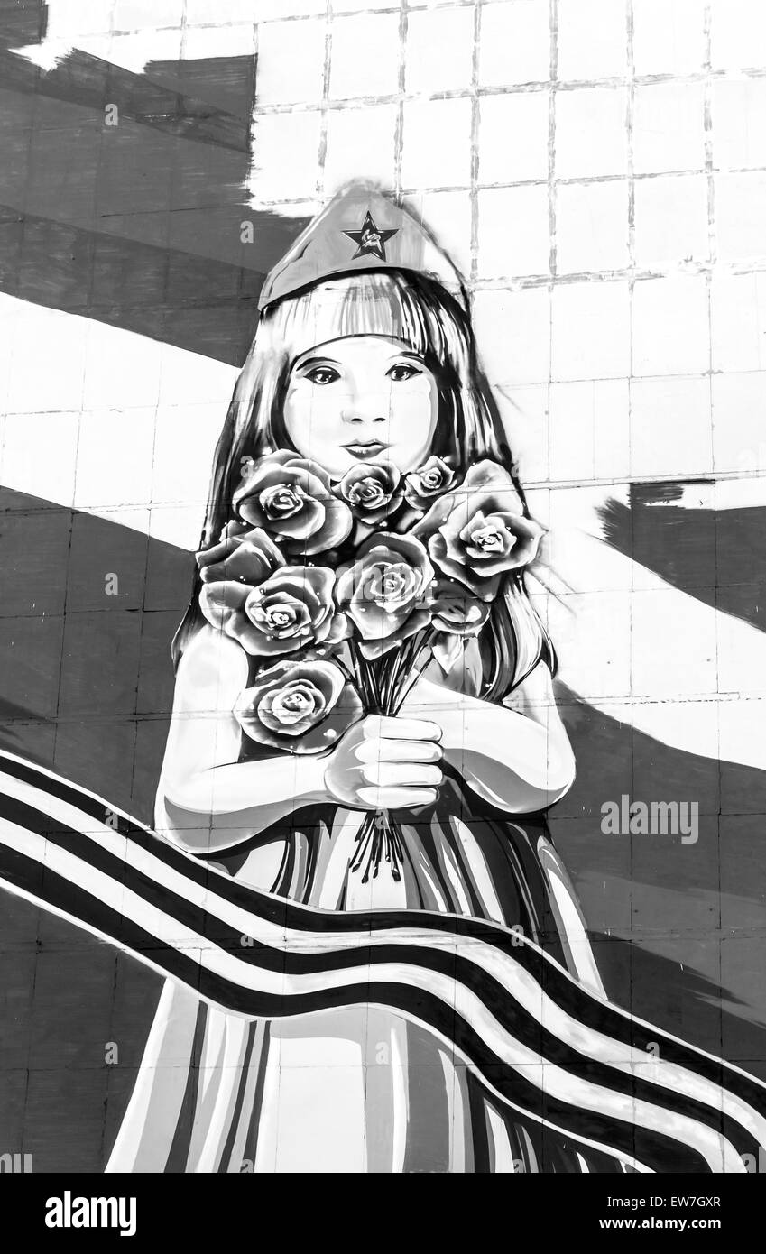 Jeune fille russe holding roses rouges en Casquette militaire et avec le ruban de St George en noir et blanc Banque D'Images