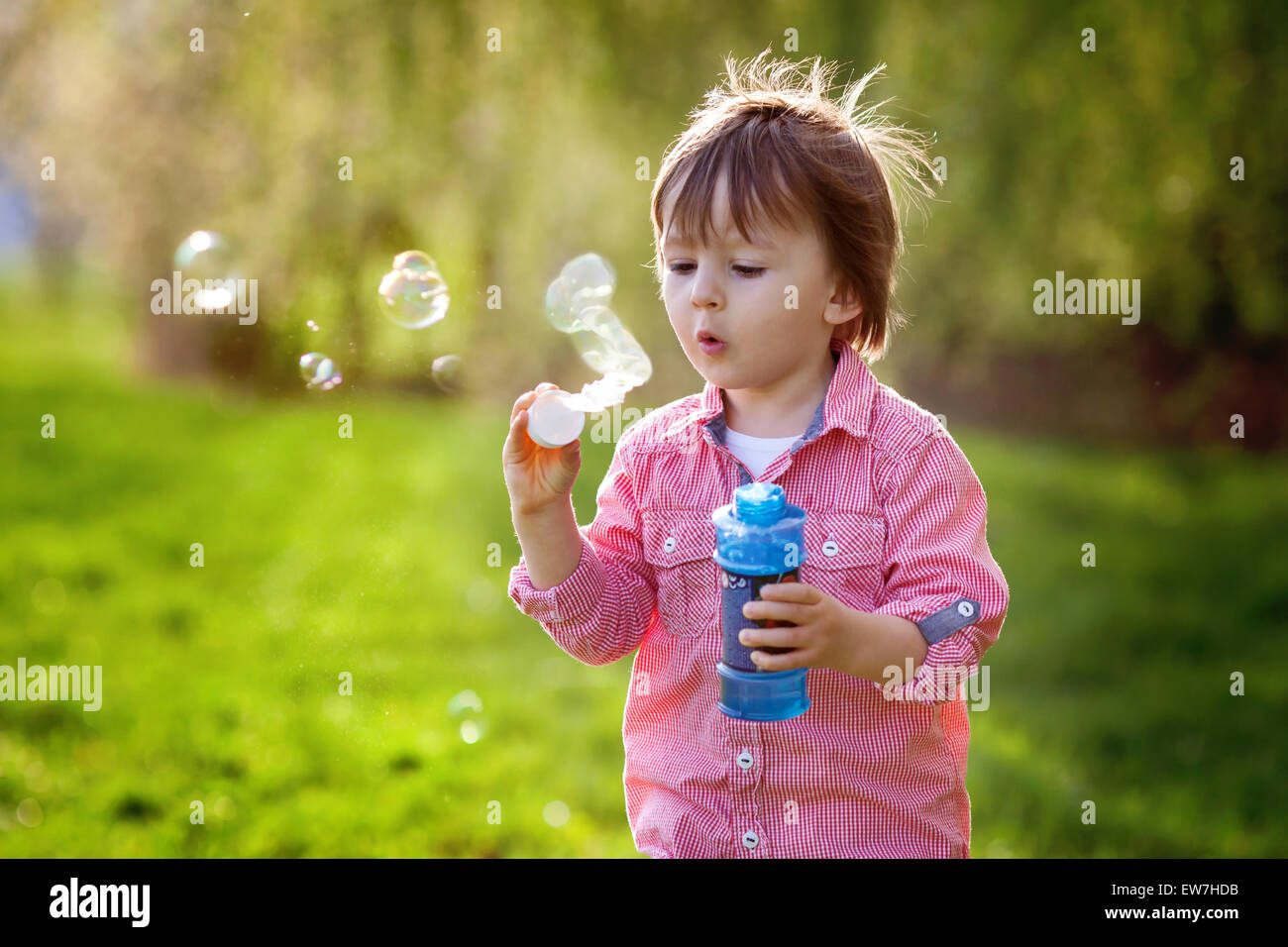 Portrait d'un charmant garçon, faisant des bulles de savon dans le parc Banque D'Images Portrait d'un charmant garçon, faisant des bulles de savon dans le parc Banque D'Images