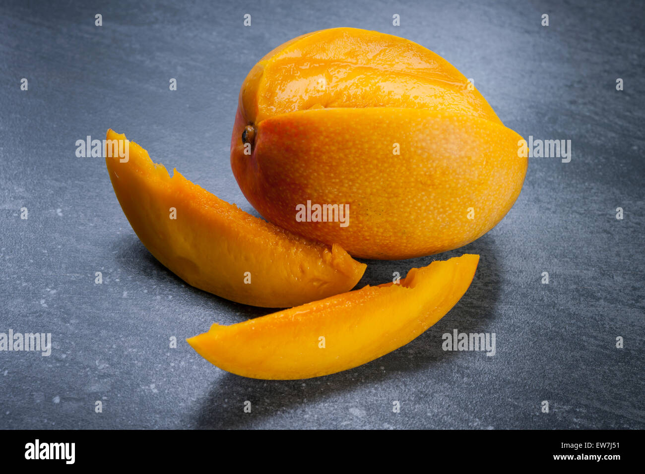 Les mangues fraîches coupées en tranches sur fond noir en gris Banque D'Images