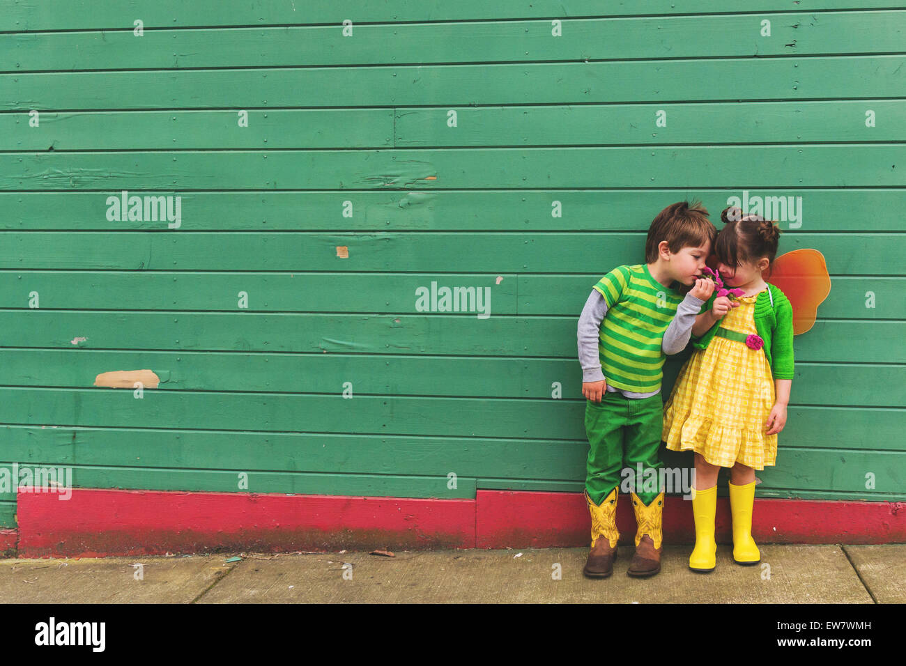 Garçon et fille habillé comme une chenille et papillon fleurs odorantes Banque D'Images