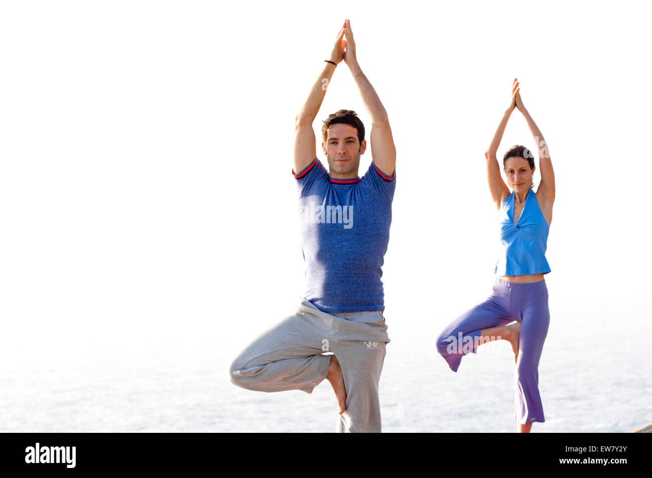 Un homme et une femme pratiquant le yoga sur un éperon rocheux au-dessus de l'océan Pacifique au nord, l'un de Curl Curl Sydneys ni Banque D'Images