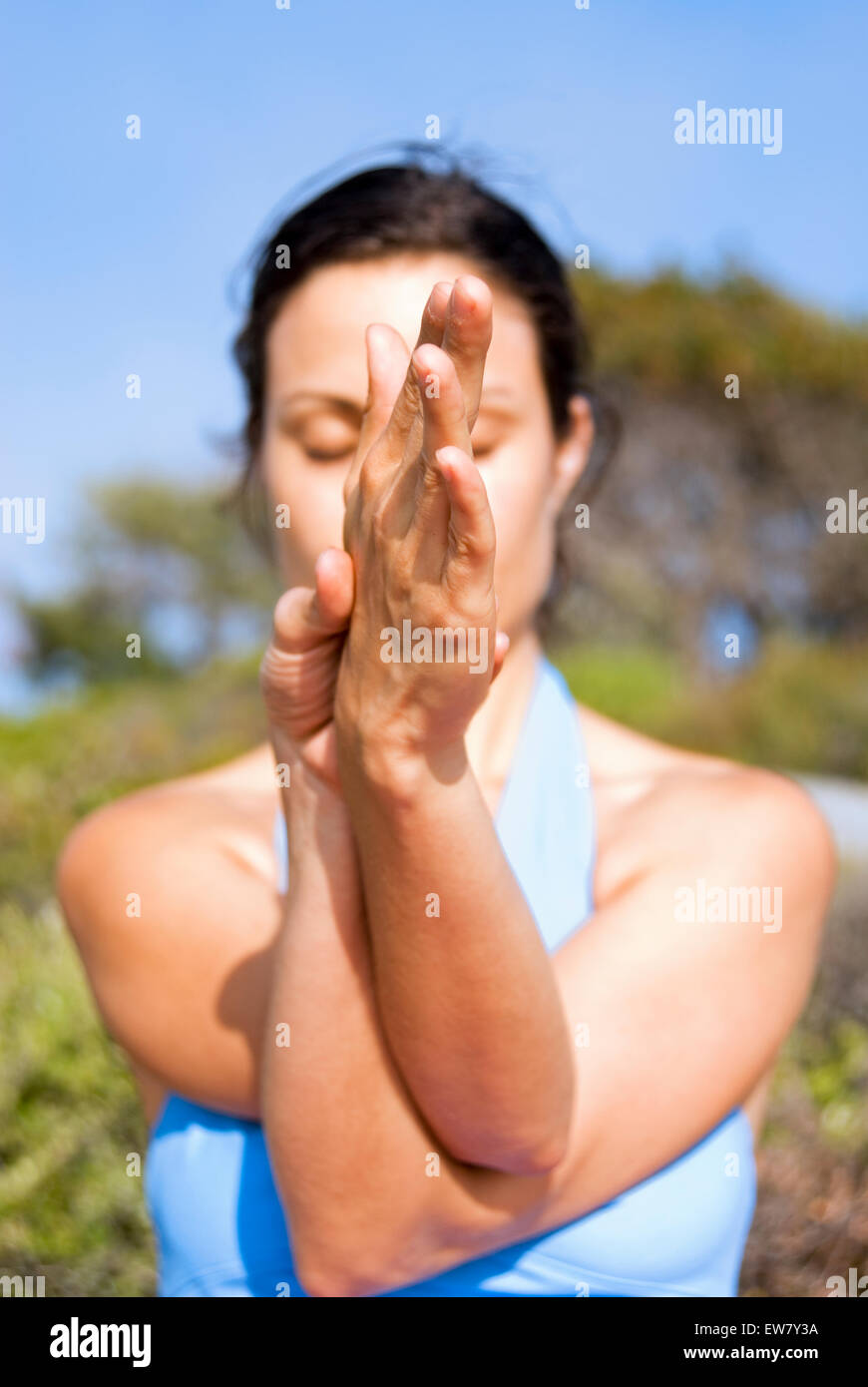 Une femme est la pratique du yoga sur un éperon rocheux au-dessus de l'océan Pacifique au nord, l'un de Curl Curl Sydneys Plages du Nord. Banque D'Images