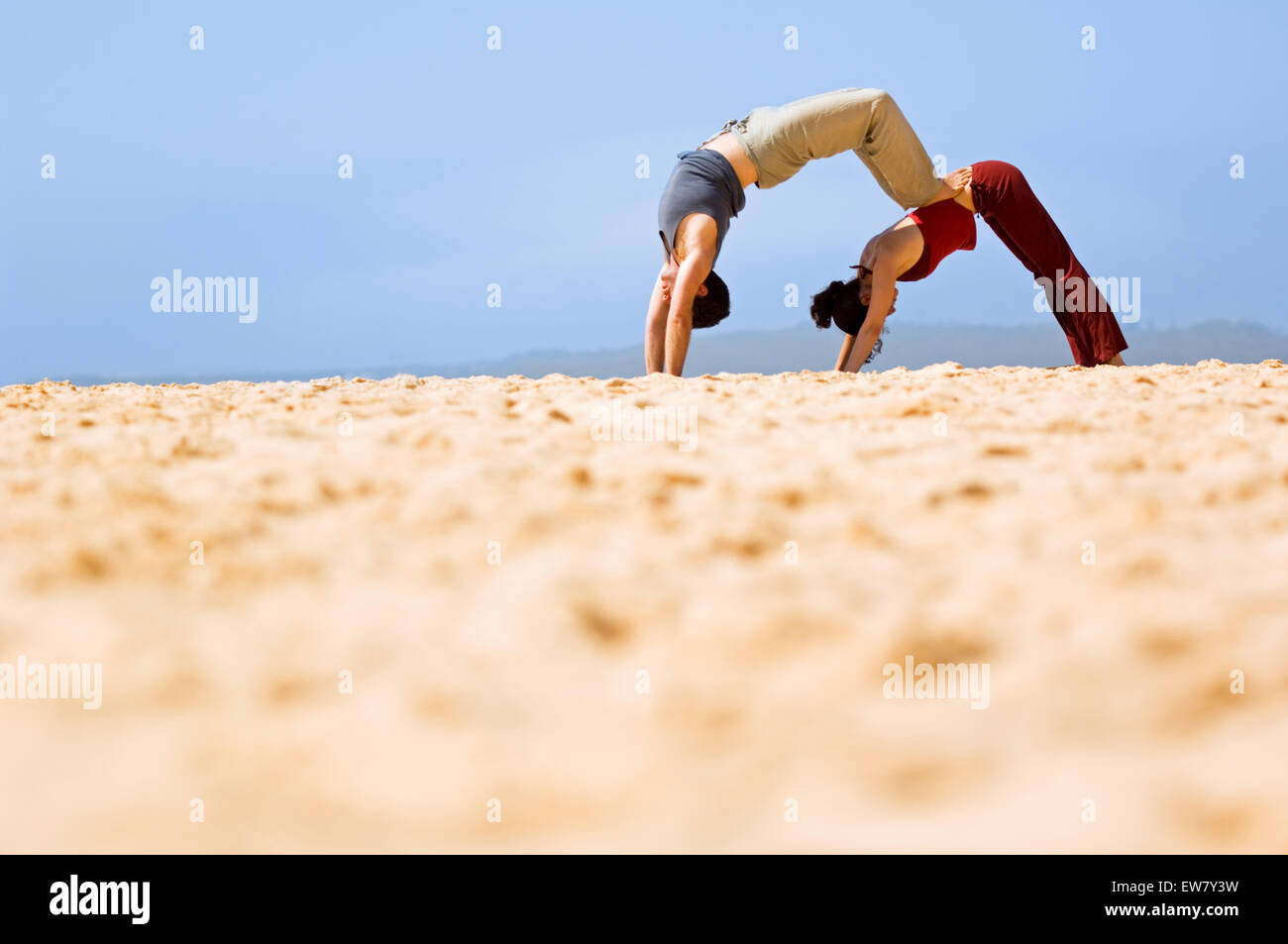 Un homme et une femme pratiquant le yoga sur un éperon rocheux au Nord, l'un de Curl Curl Sydneys Plages du Nord. Sydney, N Banque D'Images