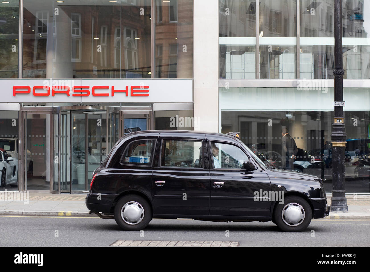 London taxi noir à l'extérieur de la Porsche show room à Londres, Angleterre Banque D'Images