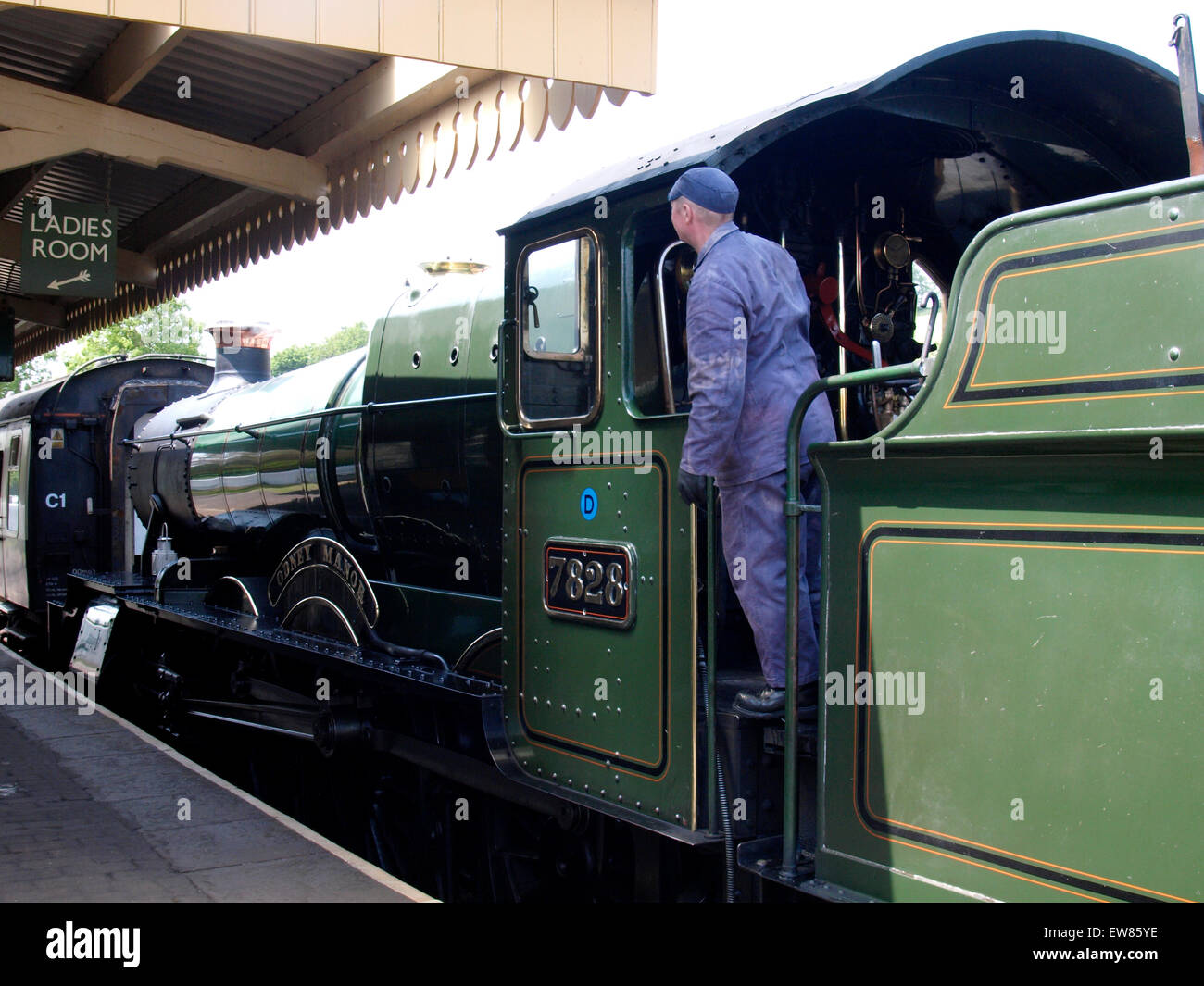 Conducteur de train à vapeur Odney Manor - 7828 En attente de l'ensemble ressort clairement de la chef de station à station Washford, West Somerset Il Banque D'Images