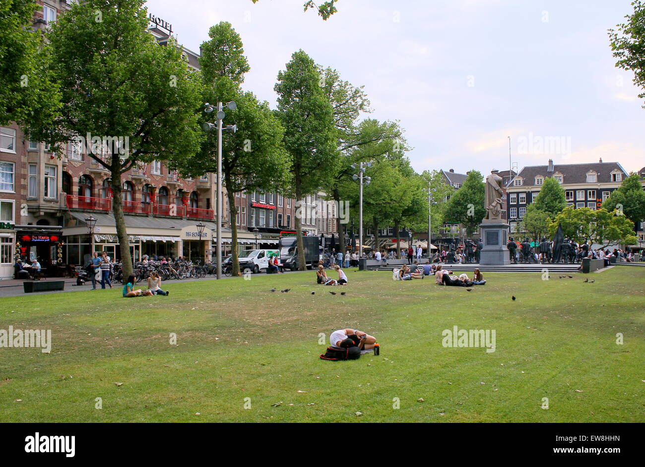 Rembrandtplein, le centre-ville d'Amsterdam aux Pays-Bas. Des gens assis sur l'herbe, les jeunes touristes étrangers profitant du soleil. Banque D'Images