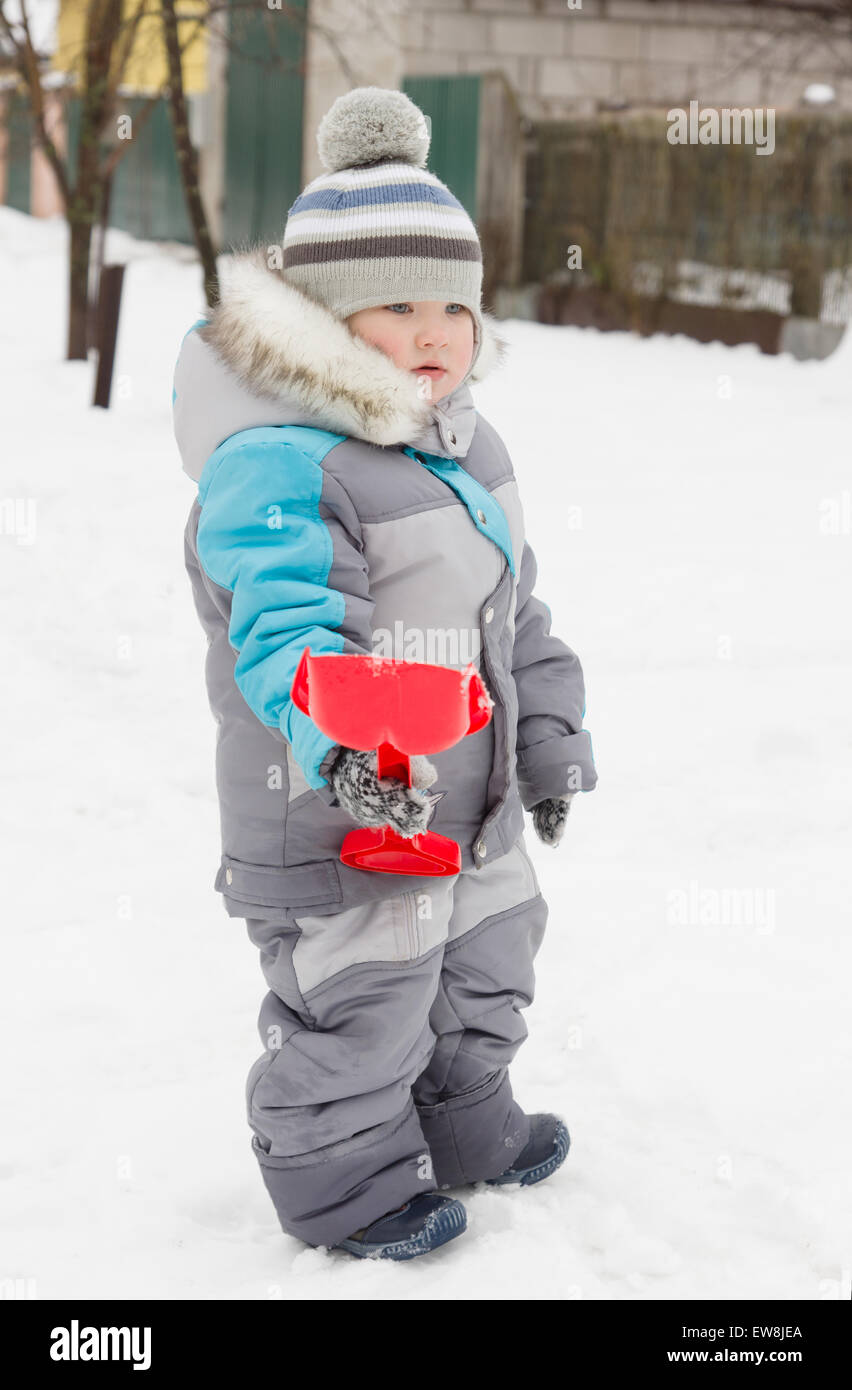 Petit garçon en salopette et les promenades sur la neige Photo Stock - Alamy