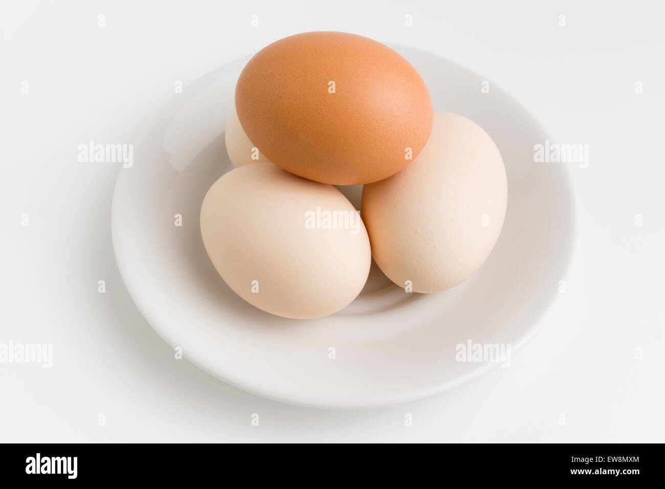 Plusieurs oeufs de poule couleurs blanc et marron sont situées sur une plaque blanche Banque D'Images