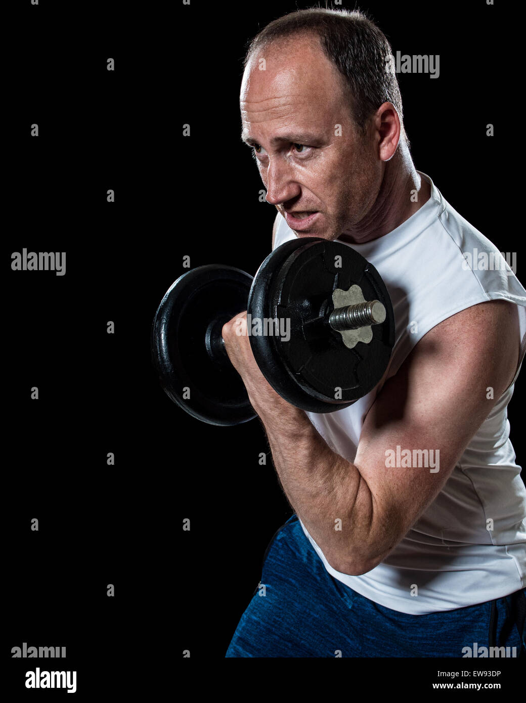 Exercice de bicep avec haltère. Studio shot sur fond noir. Banque D'Images