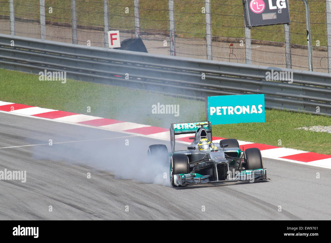 L'incident de fumée de frein de Nico Rosberg lors du Grand Prix de Malaisie 2012 met en évidence la pression intense sur le système de freinage de la voiture dans les conditions chaudes et humides de la piste. Banque D'Images