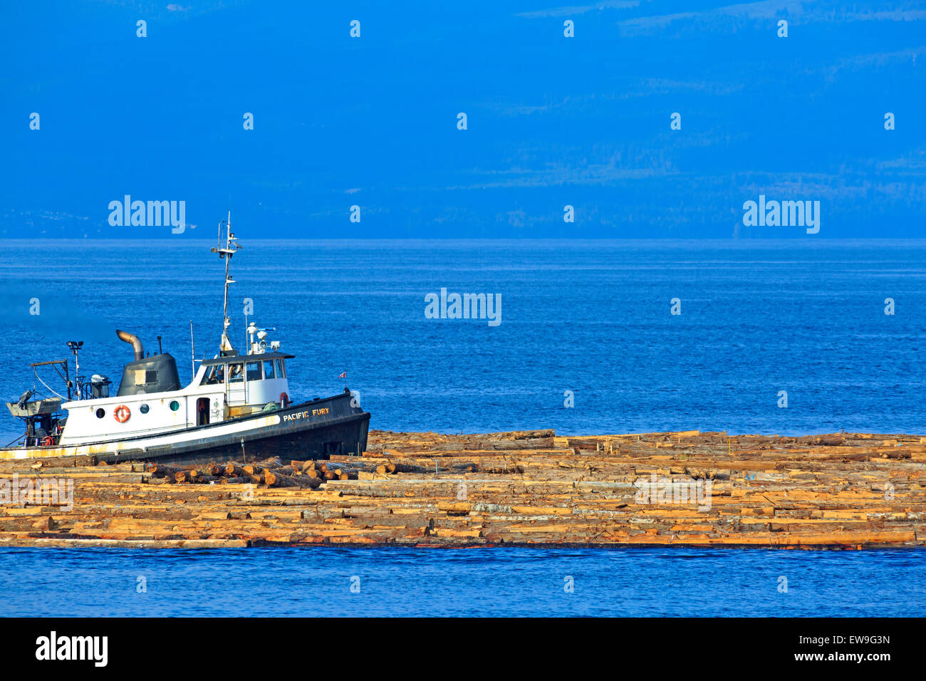 Tugboat pushing log boom dans le détroit de Géorgie, juste au nord de Nanaimo (Colombie-Britannique) Banque D'Images