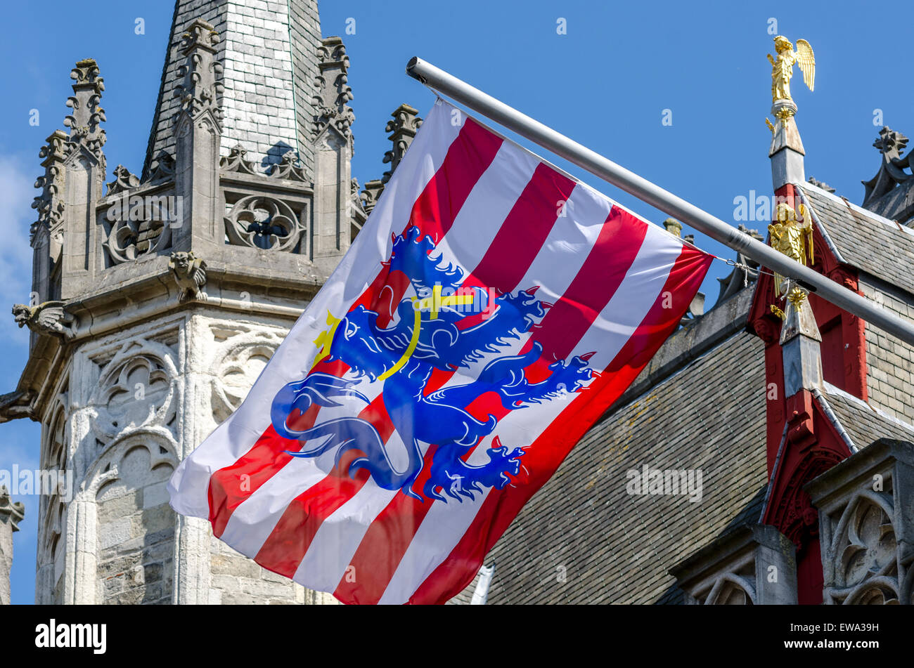 Bruges flag flying sur un contrefort du beffroi de Bruges, Belgique. Le drapeau est composé de rayures rouges et blanches avec un lion bleu Banque D'Images