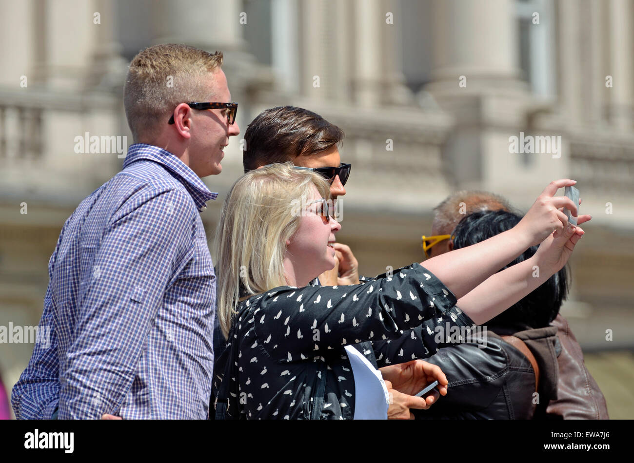 Londres, Angleterre, Royaume-Uni. Trois personnes à Piccadilly Circus en tenant un groupe selfies Banque D'Images