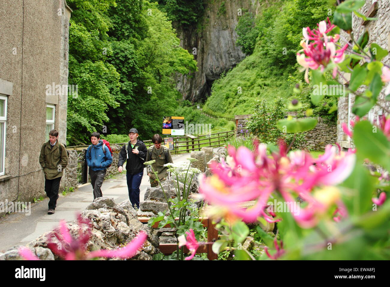 Un groupe de marcheurs, près de l'entrée de Peak Cavern, Castleton, parc national de Peak District, Derbyshire, Royaume-Uni Banque D'Images