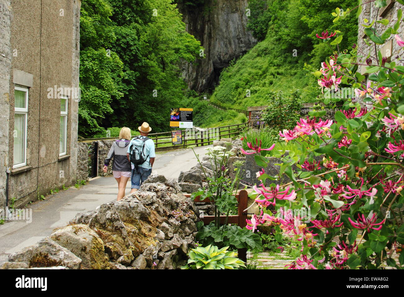 Un homme et femme s'approche de l'entrée de Peak Cavern à Castleton, parc national de Peak District, Derbyshire, Royaume-Uni Banque D'Images
