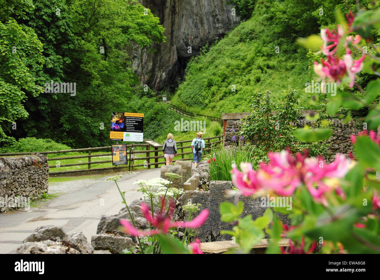 Un homme et femme s'approche de l'entrée de Peak Cavern à Castleton, parc national de Peak District, Derbyshire, Royaume-Uni Banque D'Images