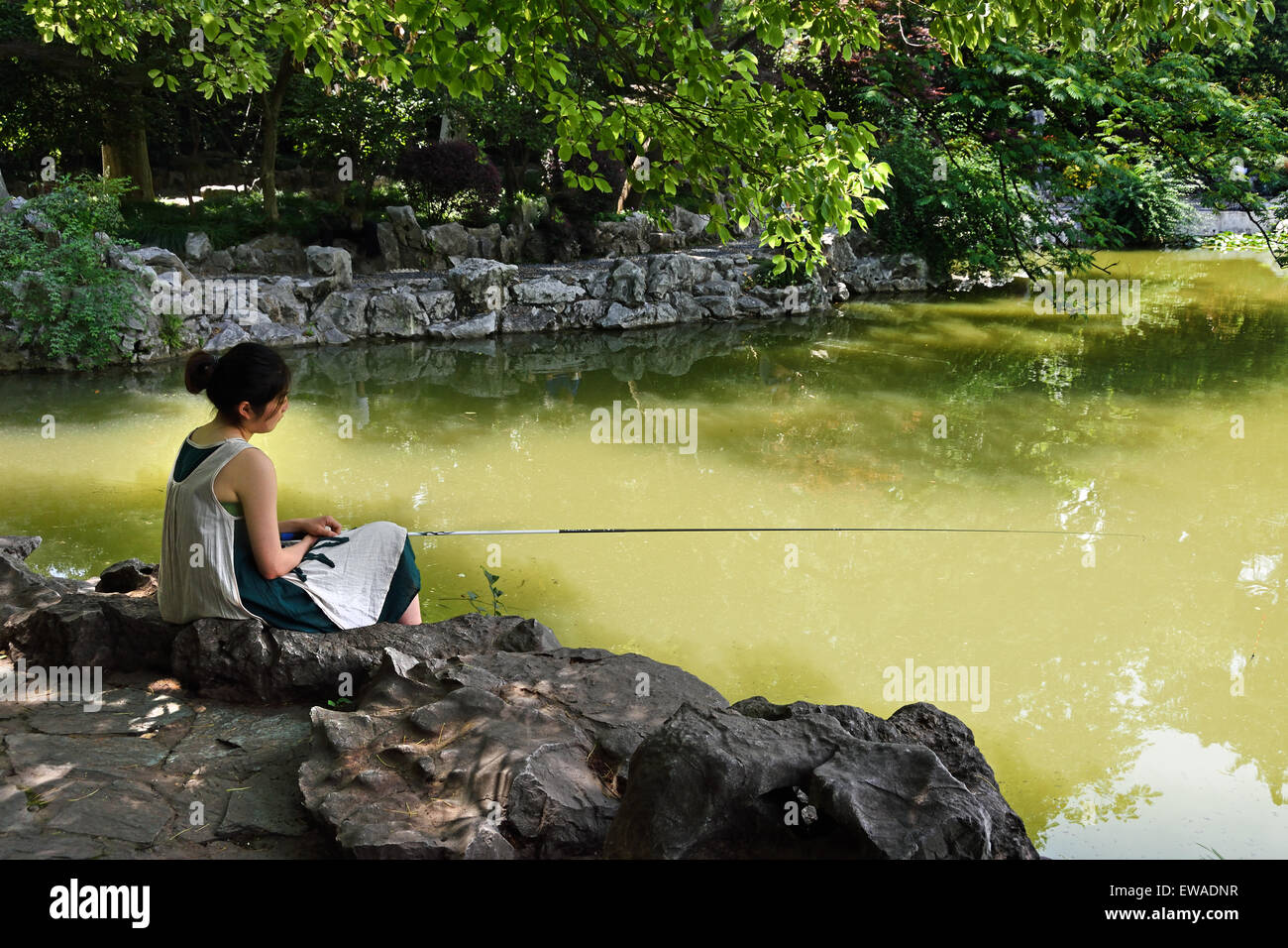 Femme Dame pêche Concession Française Fuxing Park, le quartier de Luwan à Shanghai, Chine Banque D'Images