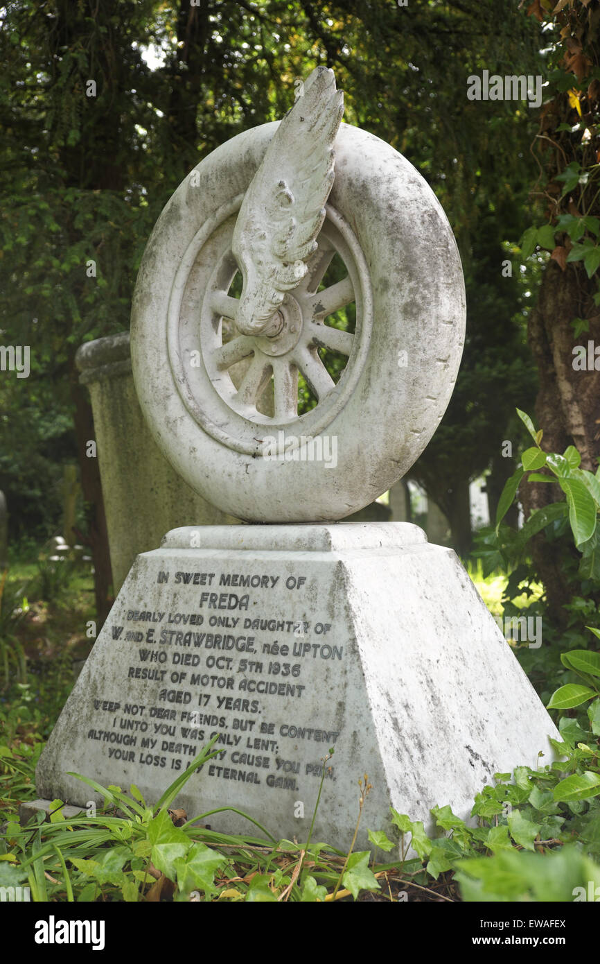 Pierre tombale inhabituelle à partir de 1936 avec un véhicule à moteur roue en cimetière à Birmingham UK Harborne. Banque D'Images