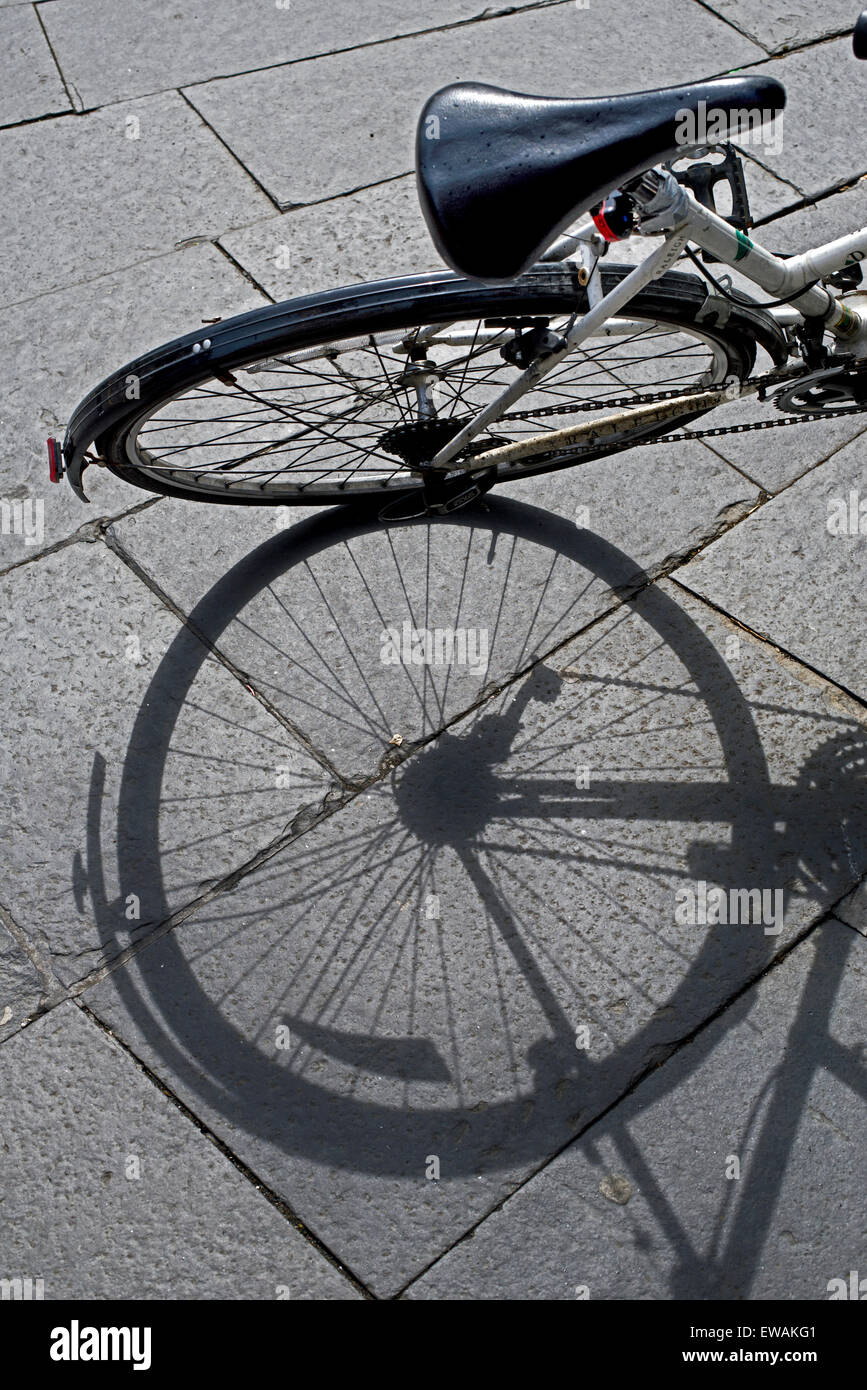 Un morceau de trottoir avec l'ombre d'une roue de vélo. Banque D'Images