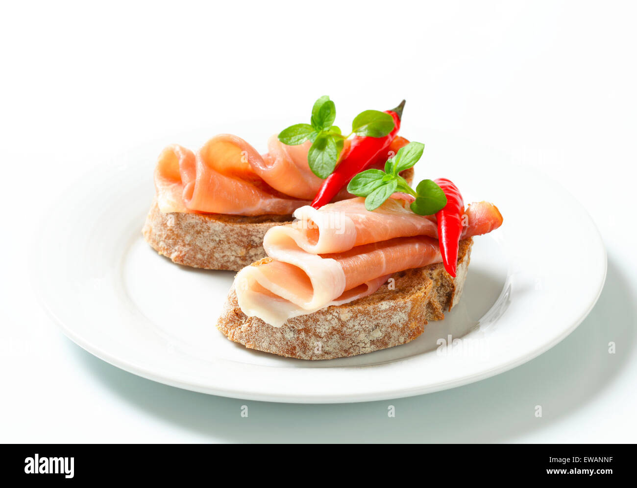 Le Prosciutto ouvert sandwiches garnis de piment rouge Banque D'Images