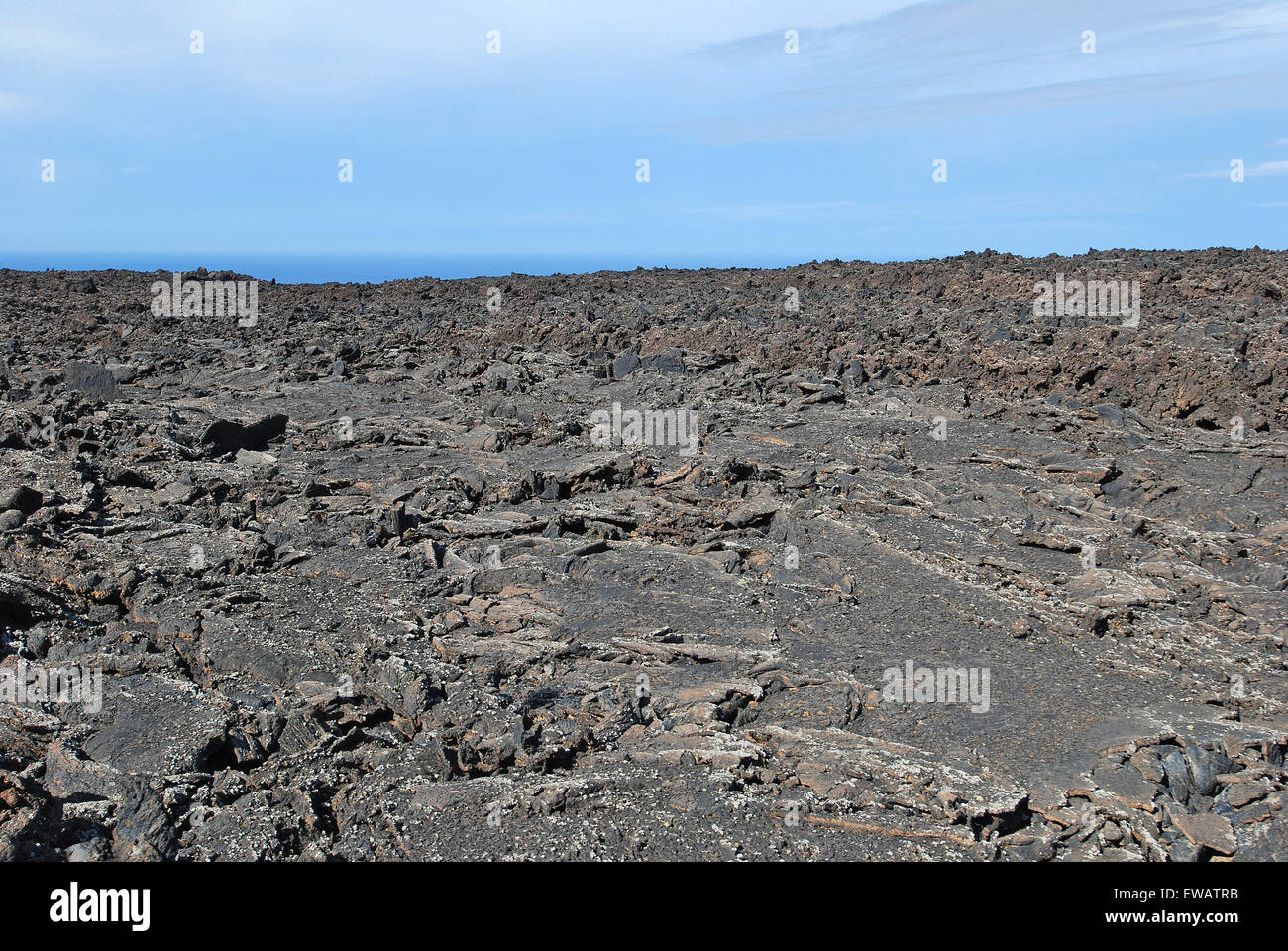 Lanzarote, îles Canaries, Espagne. Un champ de lave avec des montagnes à l'horizon, dans le parc naturel de Timanfaya. Banque D'Images