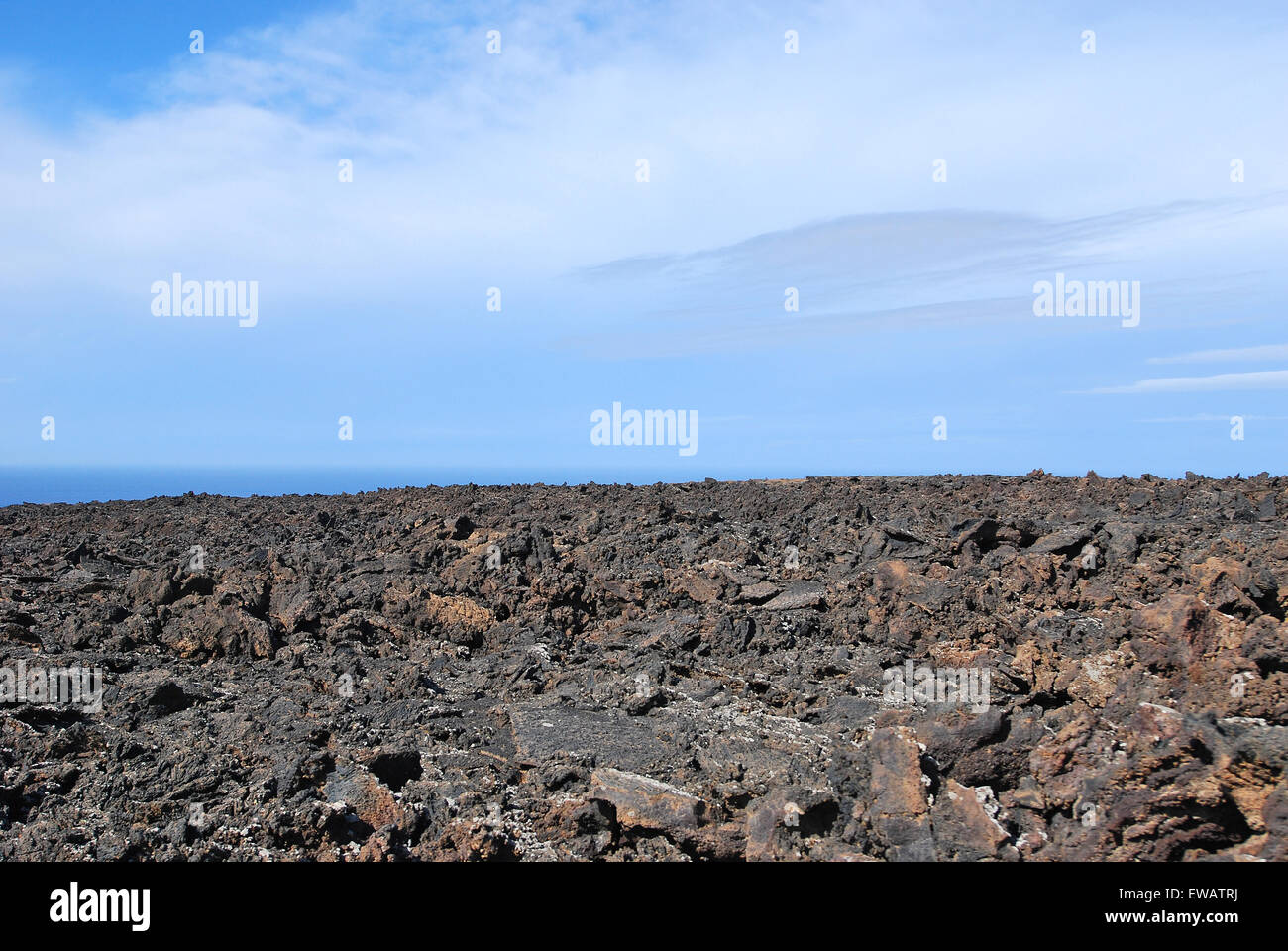 Lanzarote, îles Canaries, Espagne. Un champ de lave avec des montagnes à l'horizon, dans le parc naturel de Timanfaya. Banque D'Images
