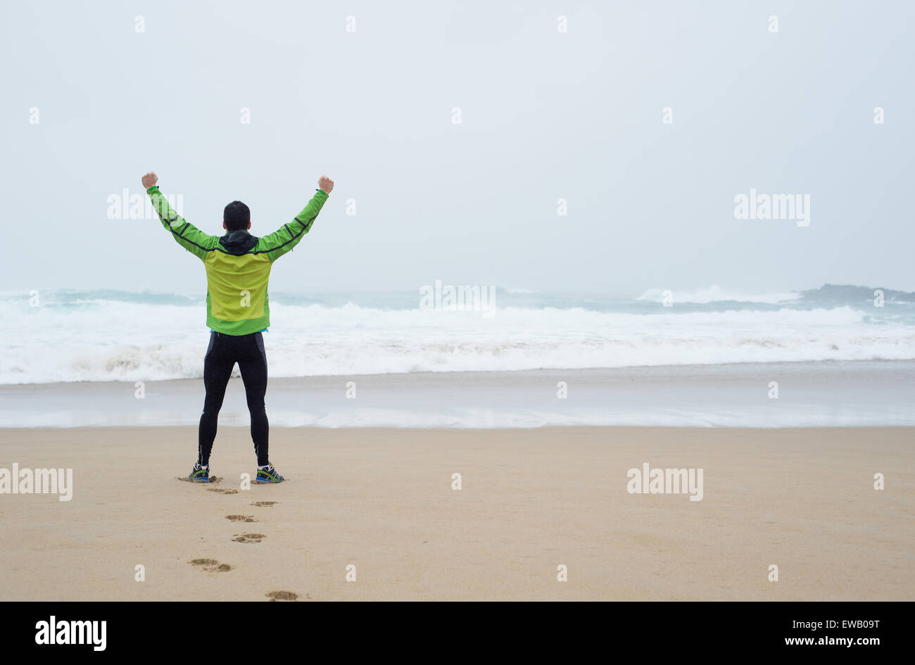 L'homme d'un coureur avec les mains jusqu'au symbole de la victoire Banque D'Images