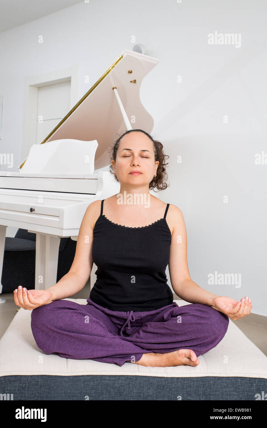 Femme d'une trentaine se détend avec le yoga Banque D'Images