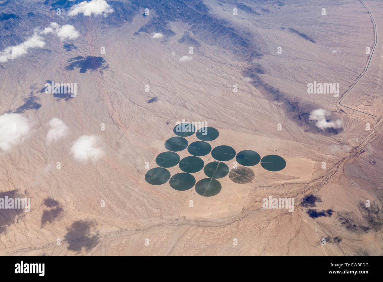 Vue aérienne de cercles de culture irriguée vert dans une vaste étendue de brun dans le désert de Mojave en Californie. Banque D'Images