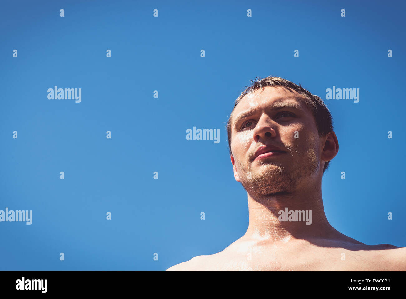 L'homme couvert de sueur et l'eau contre le ciel bleu épais. Banque D'Images