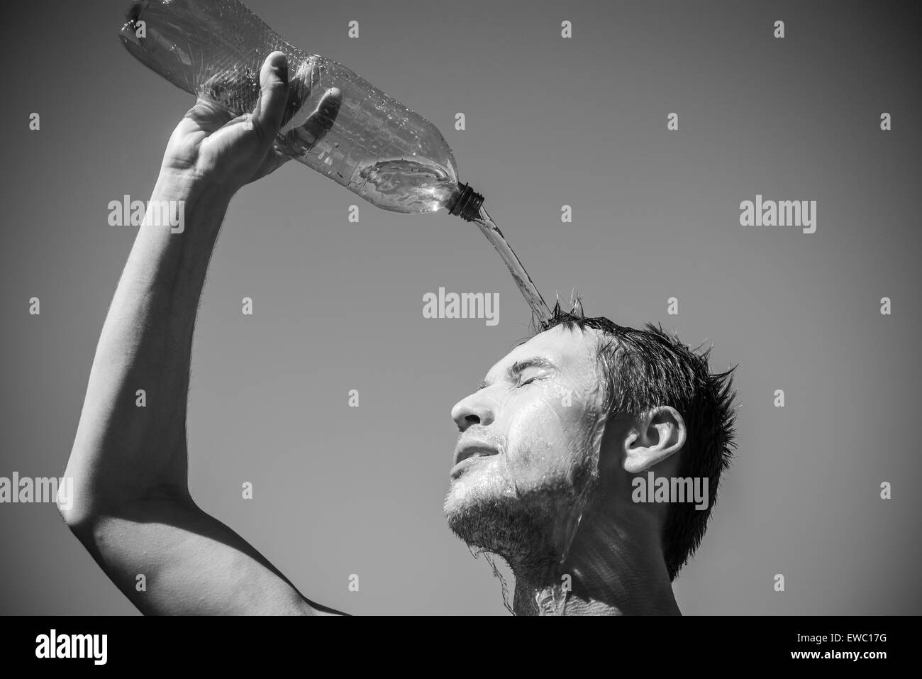 Photo d'un homme qui est couvert le visage avec de l'eau. Beau ciel en arrière-plan. Banque D'Images