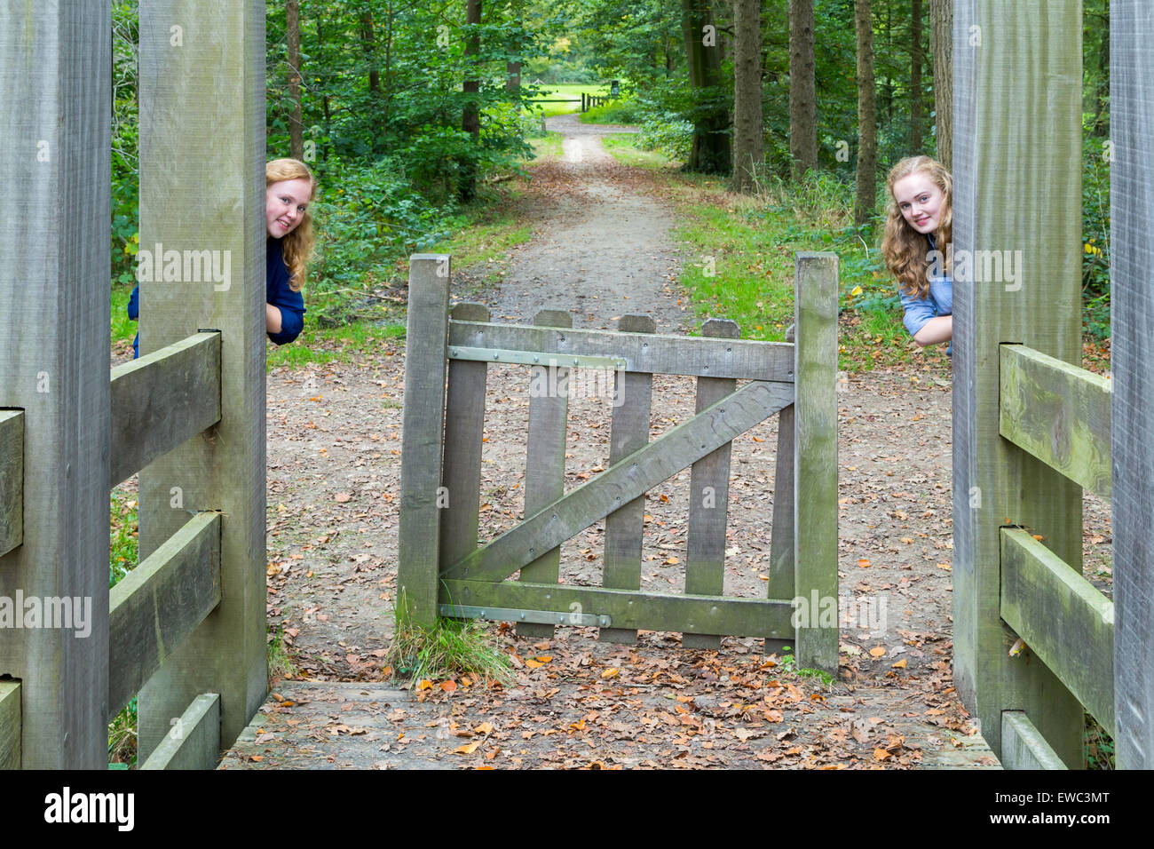 Deux adolescentes de race blanche se cacher à l'entrée en bois de sentier de randonnée dans la nature Banque D'Images