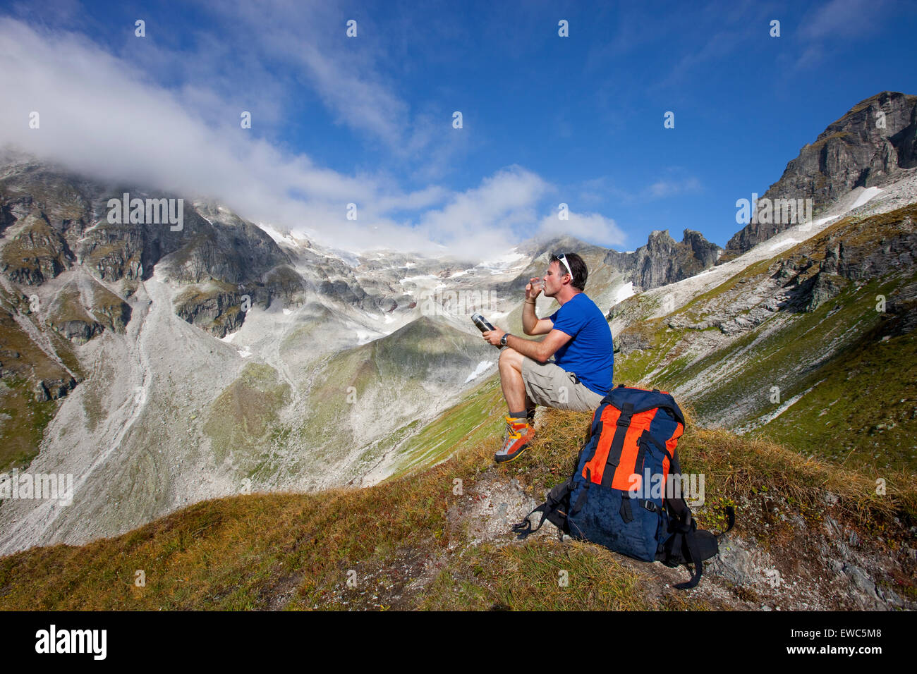 Un male hiker boit un thé pendant le Glocknerrunde, un stade 7 de trekking à Kaprun Kals autour du Grossglockner, le Banque D'Images