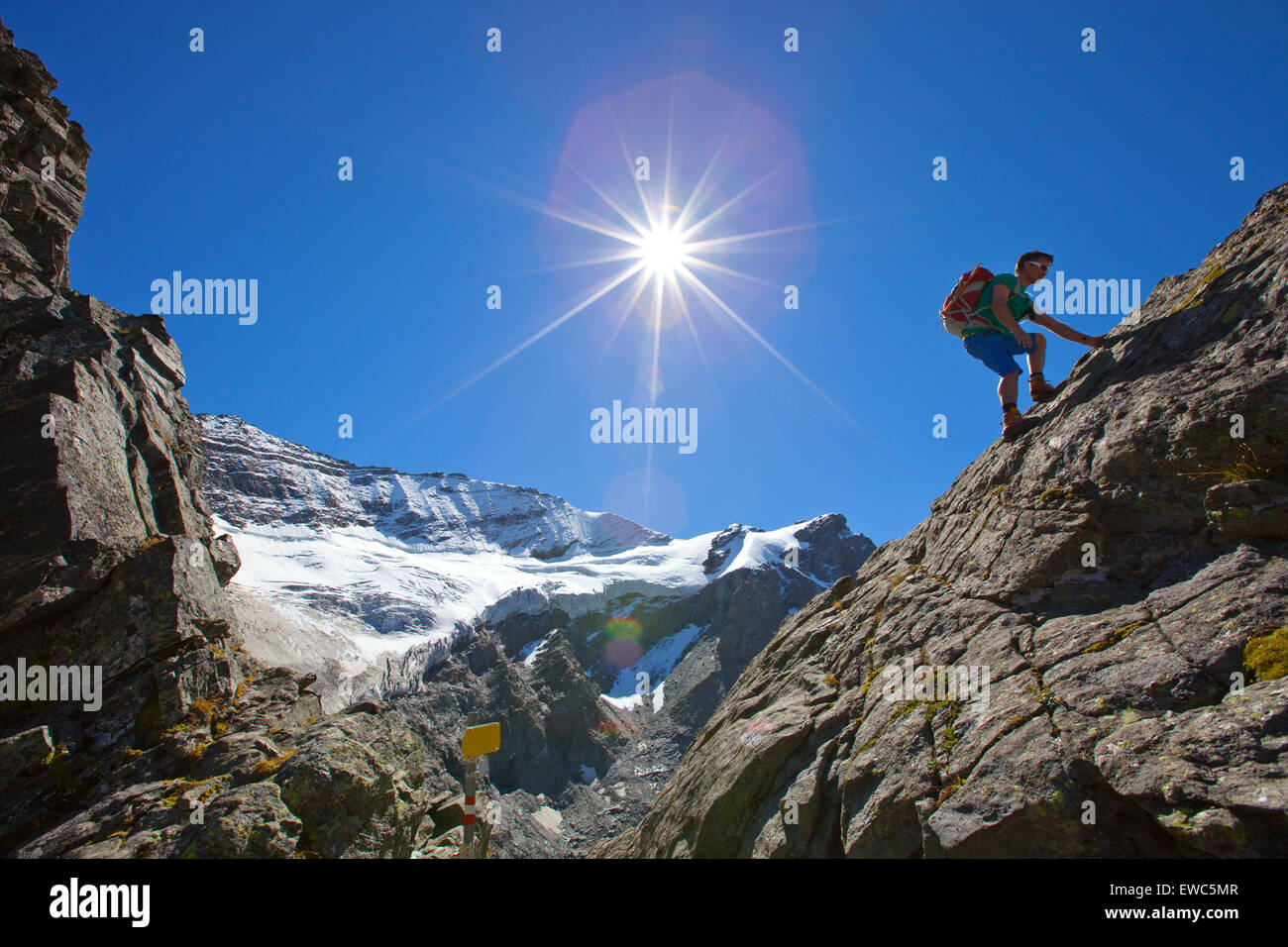 Un male hiker grimpe dans un passage rocheux au cours de l'étape 7 Glocknerrunde, un trekking de Kaprun à Kals autour du Grossglockner, Banque D'Images