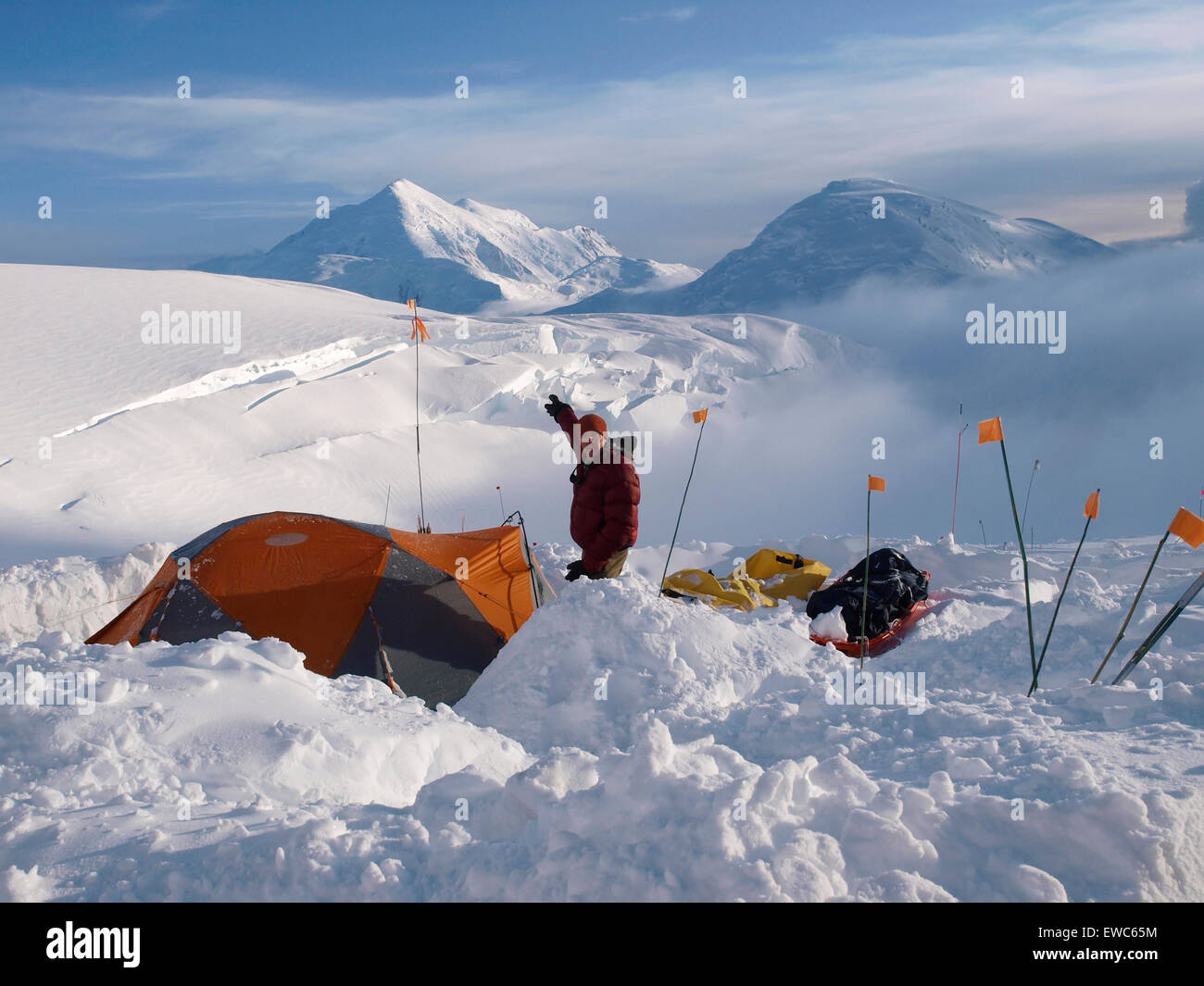 Climber et Brian rangers Scheele est debout à côté de sa tente et pointant vers le Mont Foraker de 12,000 pieds de haut camp sur le mont Banque D'Images