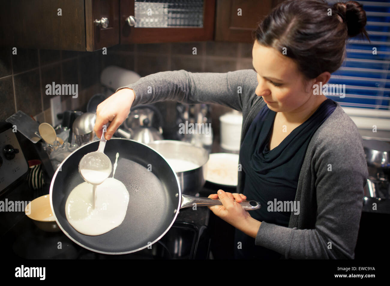Jeune femme prépare des crêpes Banque D'Images