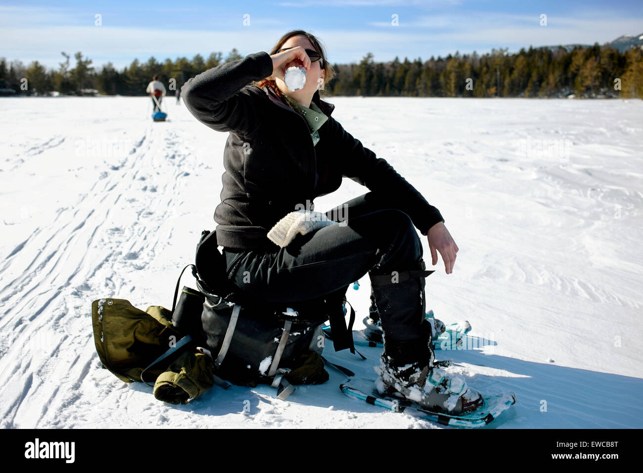 La femme boit un bière sur un lac gelé Banque D'Images