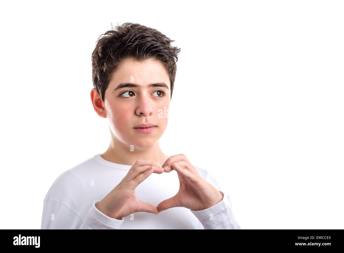 Portrait jeune garçon à peau lisse dans un livre blanc manches longues T-shirt smiles faire part coeur geste Banque D'Images