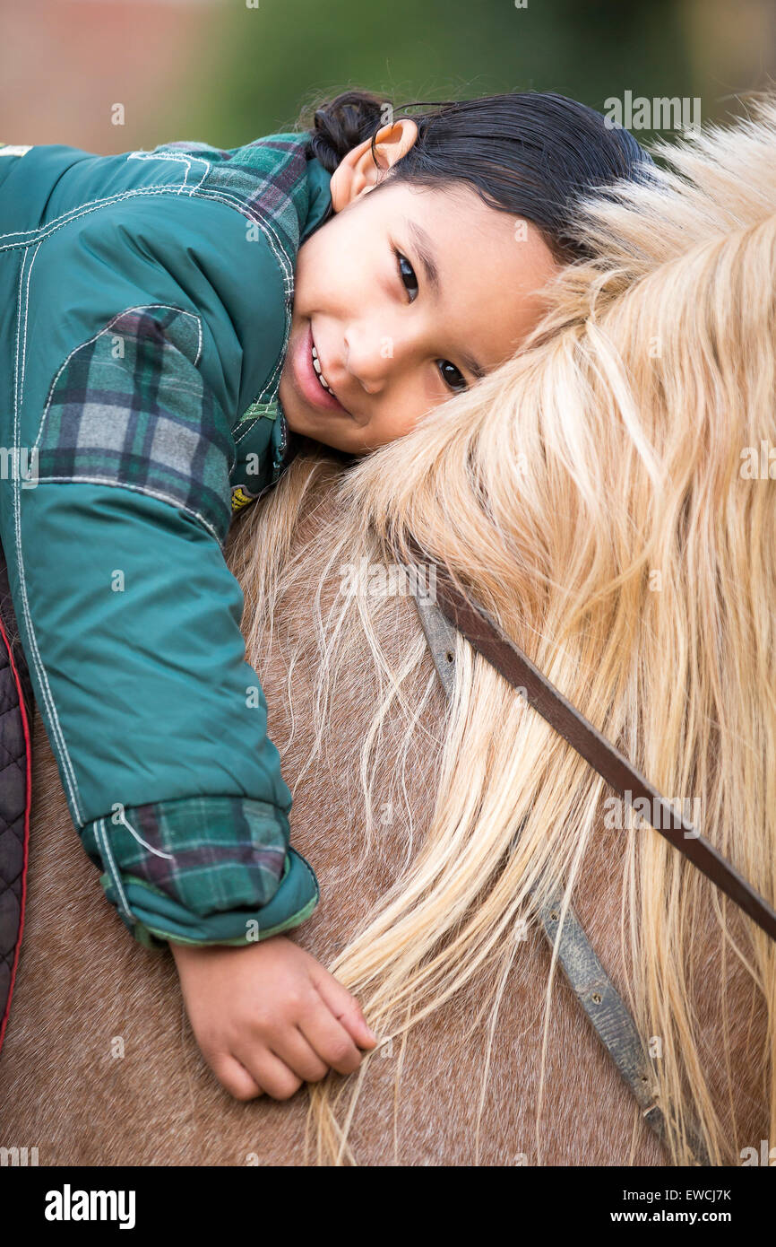 Cheval Arabe, Cheval Arabe. Petite fille allongée sur le dos d'un cheval avec la tête à la crinière. L'Égypte Banque D'Images