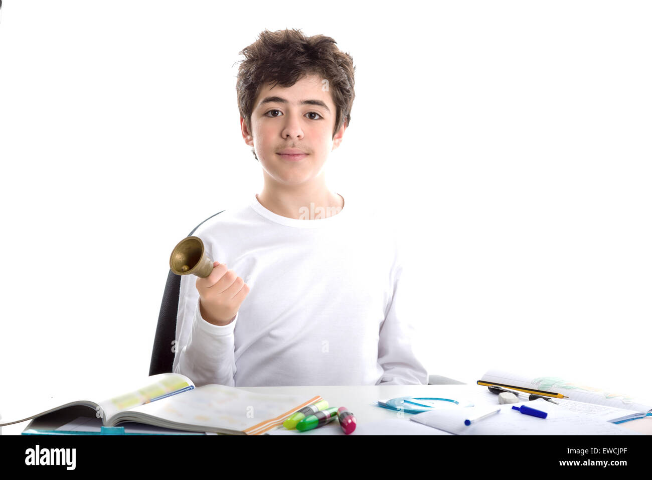 Young boy sitting à peau lisse de sonner une petite cloche à main droite tandis qu'à faire leurs devoirs Banque D'Images