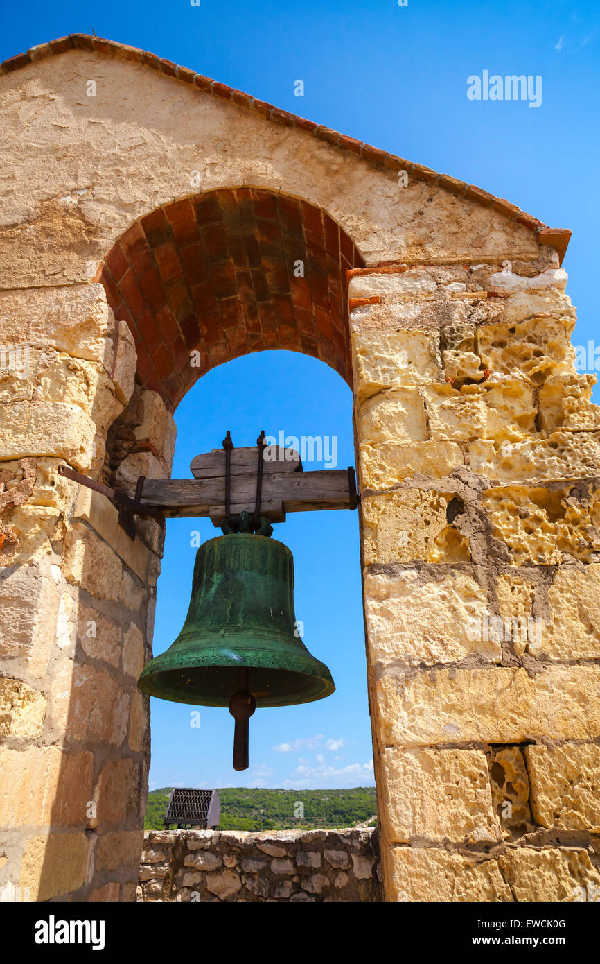 Château médiéval en pierre dans la ville de Calafell, Espagne. Bell suspendu dans arch sur fond de ciel bleu Banque D'Images