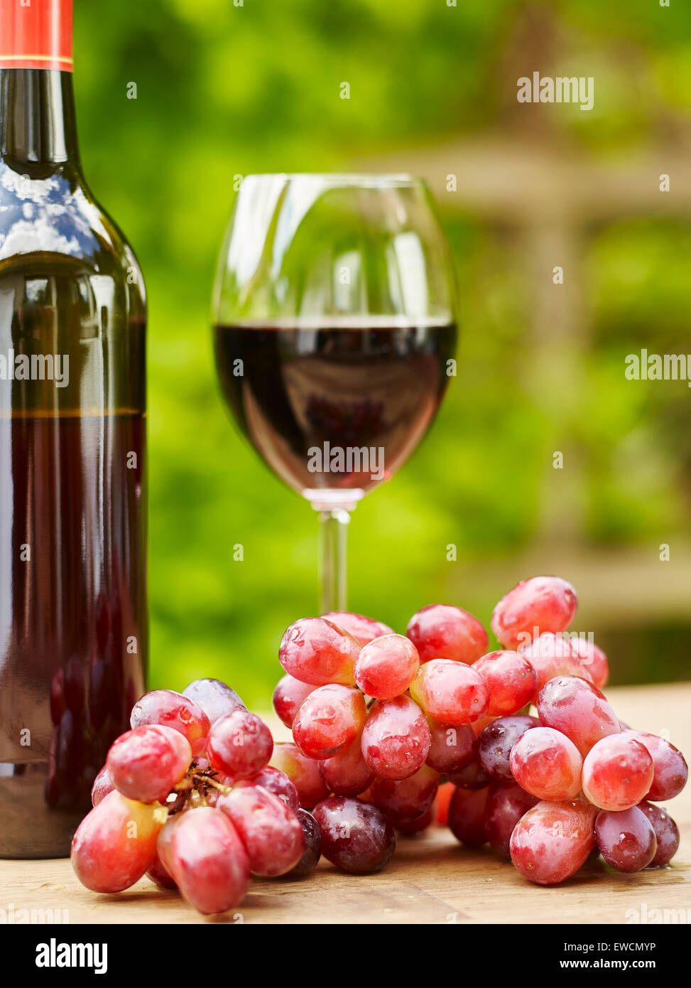 Le vin rouge, le verre et les raisins sur la table - focus sur le raisin, format vertical Banque D'Images