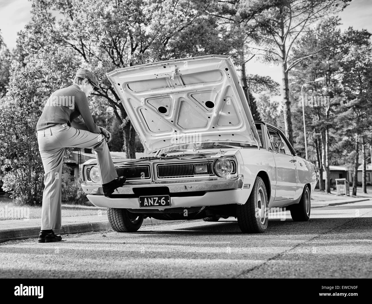 Bel homme et vieille Dodge, style années 70 thème, image en noir et blanc. Banque D'Images