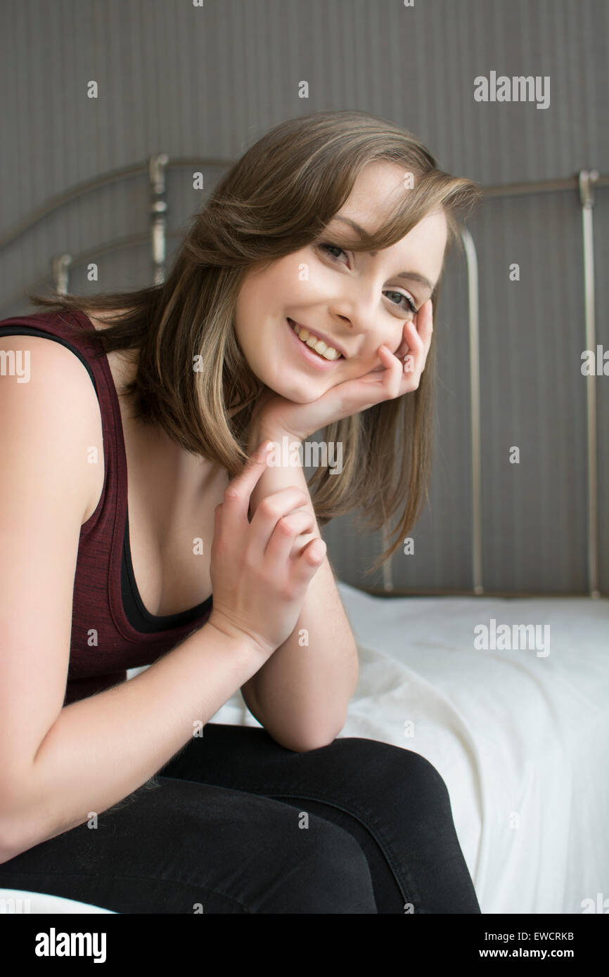 Happy young woman smiling in bed Banque D'Images