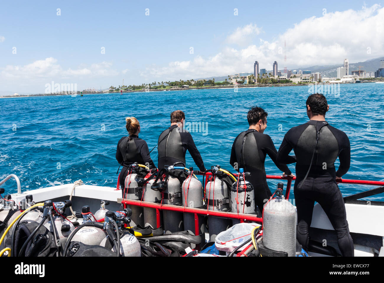 Les plongeurs en combis admirer les toits de Honolulu et Waikiki Beach, Hawaii en Oaha à partir d'un bateau avec des réservoirs de plongée sous-marine. Banque D'Images