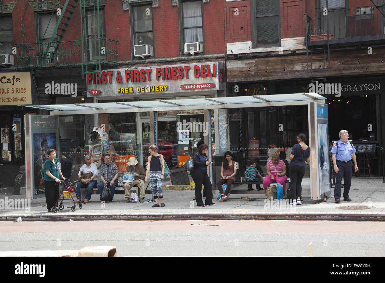 Les gens attendent pour le secteur est de la 1re avenue bus dans l'East Village, Manhattan, New York. Banque D'Images