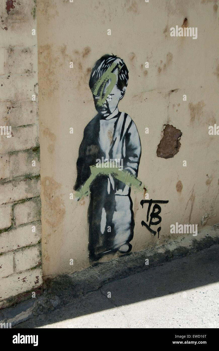 Image éditoriale d'art urbain d'un petit garçon peut-être par l'artiste de rue Banksy, qui ironiquement a été effacé par le graffiti. Banque D'Images