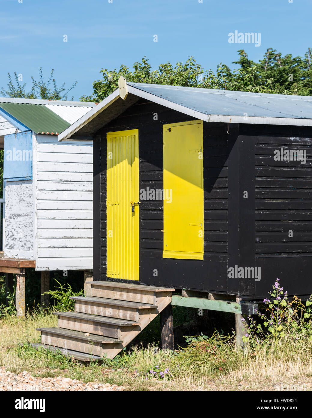 Black Beach Hut avec des portes jaunes Banque D'Images