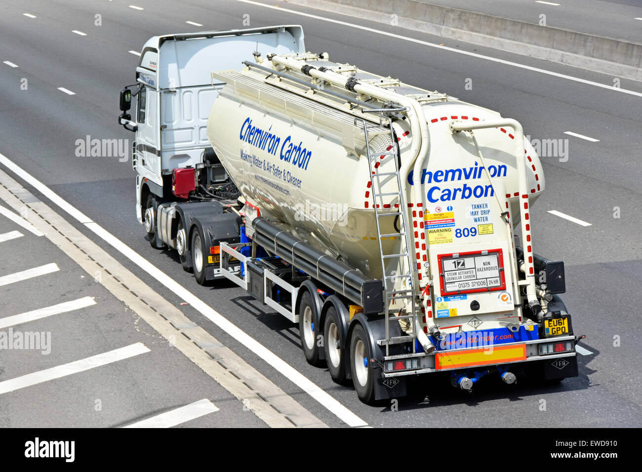 Vue arrière carbone granulaire remorque-citerne camion poids lourd articulé& camion couverts avec Santé et sécurité & automobile panneaux d'avertissement de la conduite sur autoroute britannique Banque D'Images