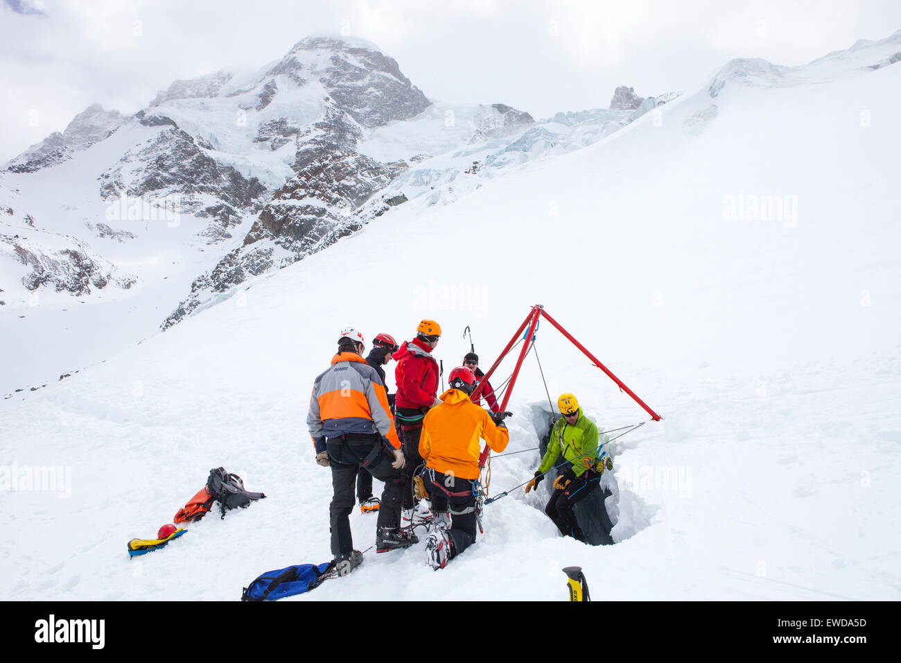 Un technicien de sauvetage en montagne est en ordre décroissant dans une crevasse. Lorsqu'un skieur se brise à travers la neige et dégringole la seule façon Banque D'Images